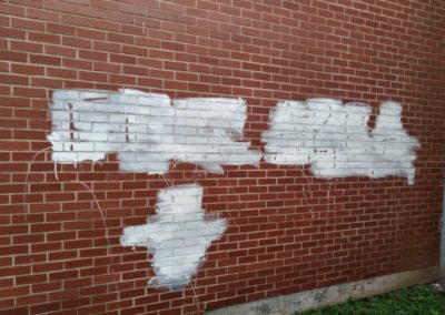 Graffeti removal on brick wall